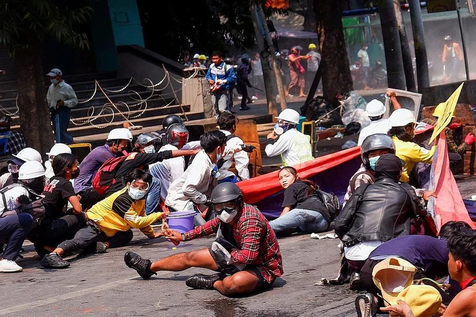 TIARAP UNTUK SELAMAT: Para penunjuk perasaan meniarap di atas jalan raya selepas pihak polis melepaskan tembakan menggunakan peluru hidup di Mandalay, Myanmar. - Foto REUTERS
