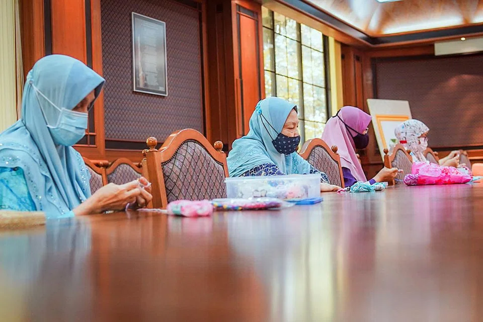 BANTU CARI DANA: Kaum Muslimah membantu mengait pengikat pelitup muka untuk dijual dan dimasukkan ke dalam dana Masjid Al-Amin. - Foto MASJID AL-AMIN