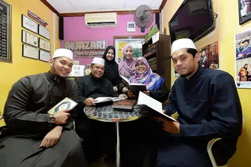 KELUARGA PENCINTA QURAN: (Dari kiri) Ustaz Zahil bersama abahnya, Ustaz Zakaria Md Shariff Alhafiz, 50 tahun, pemegang 10 qiraat dan Ketua Hakim Musabaqah Tilawah Al-Quran Kebangsaan Singapura; ibunya, Ustazah Noormala Sujuddin, 50 tahun, pemegang tujuh qiraat; kakak, Ustazah Nurzafeerah, 27 tahun, pemegang ijazah Sarjana Syariah wa Usul dari Universiti Malaya; isteri, Ustazah Sharifah Hayatunnur Mohamed, 26 tahun, pemegang ijazah Sarjana Muda Pengajian Melayu Universiti Malaya; dan adik, Ustaz Md Zaki Ariffin, 21 tahun, masih menuntut di Jordan. - Foto ZAINAL YAHYA