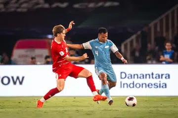 Pemain sayap Indonesia, Luke Vickery (kiri) cuba mendapatkan bola daripada pemain Singa, Nur Adam Abdullah dalam perlawanan pertama kededua pasukan Piala Asean pada 25 September. Indonesia menang 2-0 di padang sendiri.