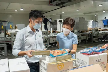 CUKUP BEKALAN: Menteri Kemampanan dan Sekitaran, Cik Grace Fu (kanan) mengunjungi stor Jurong Cold Storage untuk melihat kemudahan simpanan dan bekalan makanan laut beku seperti udang, ikan siakap dan kerapu. - Foto MSE