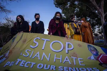 HENTIKAN SIKAP PERKAUMAN: Orang ramai berkumpul dan memegang sepanduk yang menentang keganasan yang disasarkan kepada masyarakat Asia-Amerika. - Foto AFP