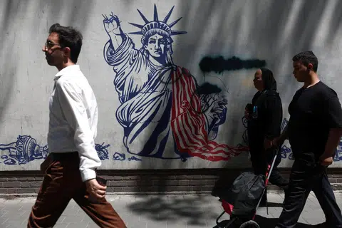 Penduduk Tehern berjalan melepasi mural anti-Amerika di sebuah jalan di Teheran pada 1 Jun 2026.