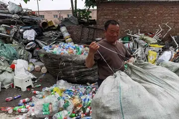 CHINA: Seorang lelaki membungkus sisa plastik di sebuah tempat buang sampah di luar Beijing. 