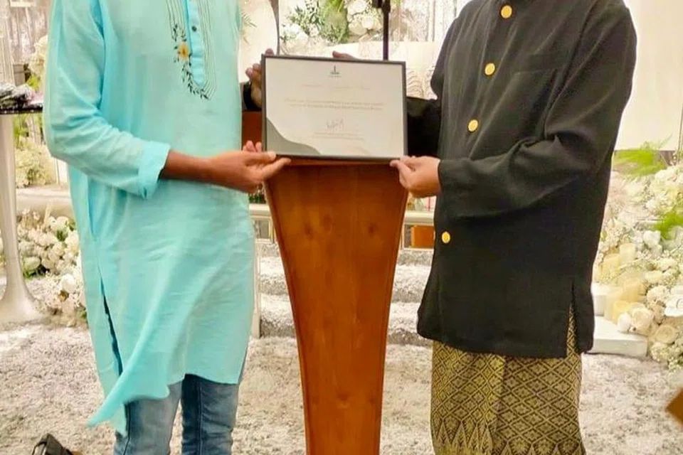 RELAWAN BERBAKTI: Sukarelawan Masjid Alkaff Kampung Melayu (MAKM) asal Bangladesh, Encik Jasim Uddin (kiri), telah mendapat penghargaan daripada pihak MAKM yang diwakili Pengerusi masjid, Encik Mohamed Faizul Othman, atas usahanya menabur bakti sepanjang Ramadan lalu. 