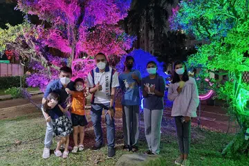 BERAMAH MESRA: Encik Zhulkarnain (tengah) bergambar bersama penduduk Keat Hong dengan berlatarbelakangkan warna-warni lampu Hari Raya. 
