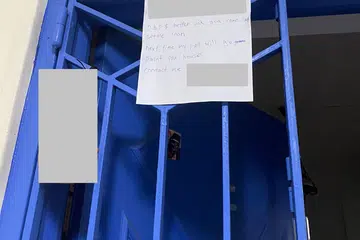 NOTA DITAMPAl: Sekeping nota ini ditampal pada sebuah unit di Woodlands Street 82.