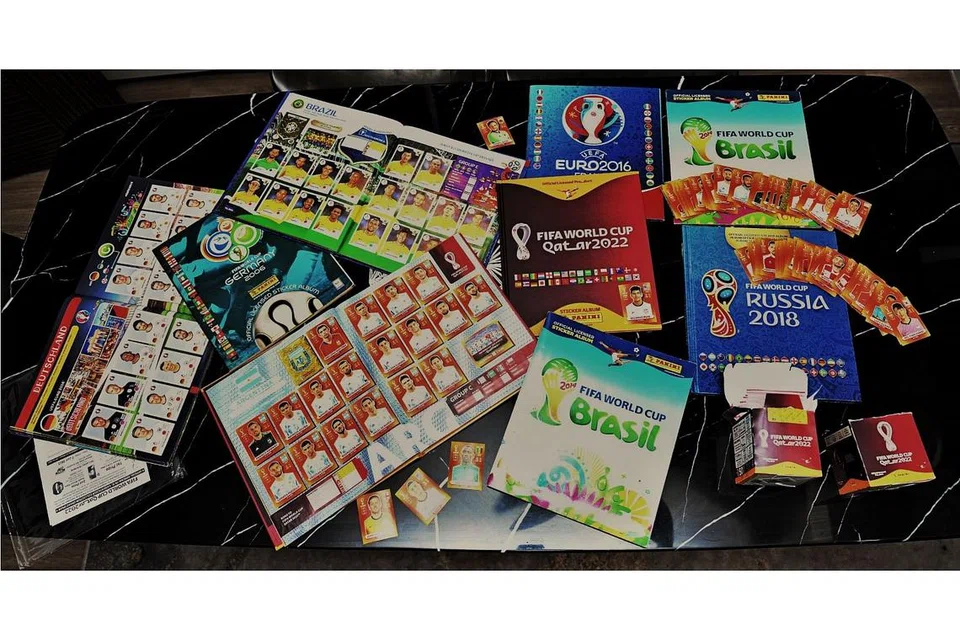 KEGIATAN 'TERAPEUTIK': Antara koleksi album dan pelekat Piala Dunia dan kejohanan Euro Suhaimi dan Suhairi.