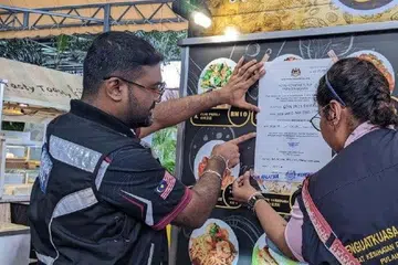 Pegawai Penguat Kuasa Pejabat Kesihatan Daerah Timur Laut dan KPDN melakukan pemeriksaan terhadap gerai di medan selera New World Park, Jalan Burma, Georgetown, Pulau Pinang.