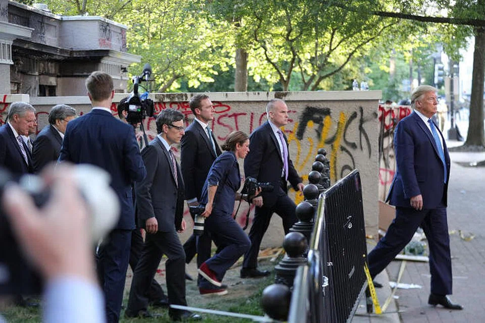 HADAPI KEMARAHAN RAKYAT: Presiden Amerika Syarikat, Encik Donald Trump, yang diiringi pengawal dan kakitangannya kelihatan melepasi sebuah bangunan yang diconteng para penunjuk perasaan di Lafayette Park yang terletak berhampiran Rumah Putih selepas sesi bergambar di Gereja St John semalam, ketika berlakunya tunjuk perasaan sebagai membantah tindakan polis yang menyebabkan kematian warga berkulit hitam, Encik George Floyd, di Minneapolis, semasa dalam tahanan polis.