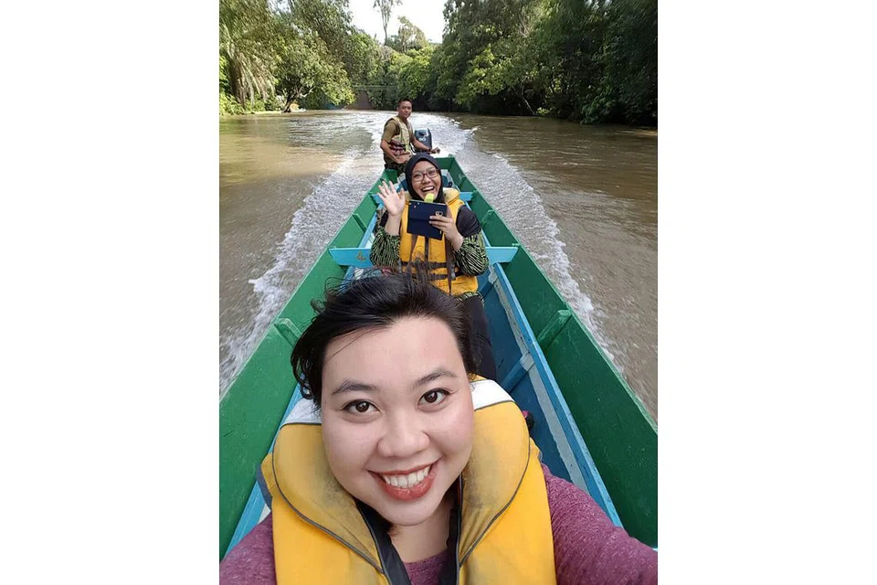 TEROKA SUNGAI: Penulis (melambai) dan rakan Syahirah (depan) menaiki bot temuai di Sungai Temburong. - Foto NURUL AIN RAZALI