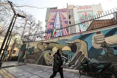 Seorang wanita Iran berjalan melepasi sepanduk anti-Amerika Syarikat dan anti-Israel yang digantung pada sebuah bangunan di Dataran Palestin, Teheran, pada 27 Januari. Sebuah kumpulan serangan tentera laut Amerika yang diketuai kapal pengangkut pesawat telah dikerahkan ke perairan Asia Barat, menurut kenyataan Washington pada 26 Januari, ketika Teheran memberi amaran bahawa ia bersedia membalas sebarang serangan Amerika susulan tindakan keras terhadap bantahan antipemerintah. 