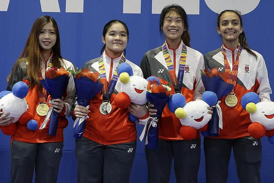 PERTAHAN TAKHTA: Kuartet pasukan lawan pedang foil wanita Singapura (dari kanan) Amita Berthier, Denyse Chan, Maxine Wong dan Tatiana Wong berjaya mengalahkan Vietnam 45-29 untuk meraih pingat emas dalam acara lawan pedang berpasukan foil wanita semalam. - Foto BH oleh MARK CHEONG