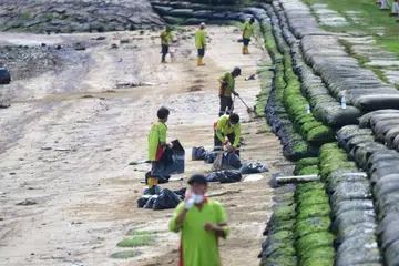 Pekerja sedang membersihkan tumpahan minyak di Kawasan 1 Pantai Pasir Ris pada 4 April.
