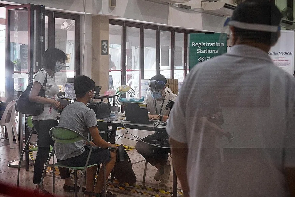 DEMI KEMASLAHATAN SEMUA: Seorang pelajar ditanya beberapa soalan oleh kakitangan perubatan sebelum divaksinasi di pusat vaksinasi di Kelab Masyarakat Tanjong Pagar semalam. - Foto BH oleh KUA CHEE SONG