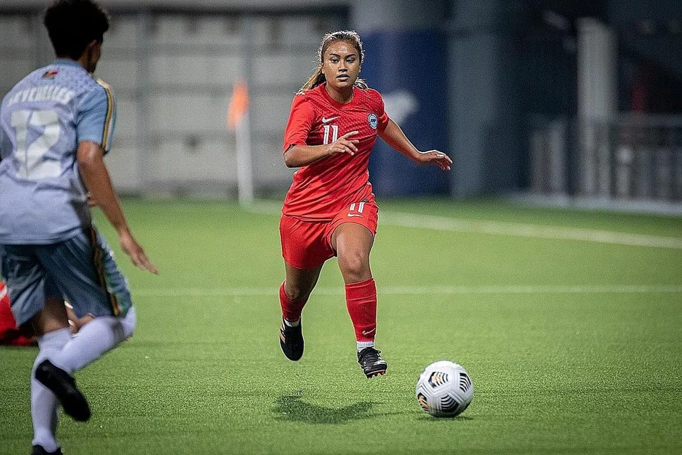 PERKUAT PASUKAN: Putri (kiri, jersi merah), yang pulang dari pengajian di Amerika bagi menyertai skuad nasional, beraksi semasa kemenangan 6-2 Singapura ke atas Seychelles di Stadium Jalan Besar Isnin lalu. - Foto FAS