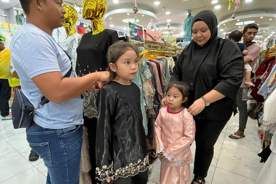 Cik Shahirah Nortasha Baharom, 30 tahun (kanan), bersama suami mencuba pakaian untuk dua anak perempuan mereka berusia sembilan dan empat tahun di Jalan Tuanku Abdul Rahman, Kuala Lumpur. 