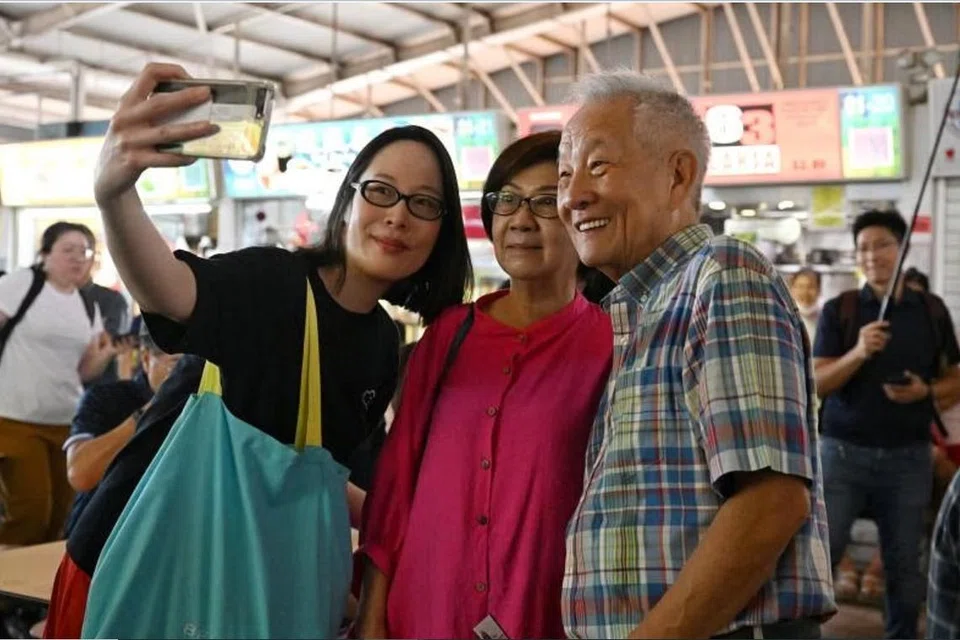 GUNA DUIT SENDIRI: Encik Ng (kanan) dan tunangnya, Cik Lau (kiri) bertemu penduduk di Pusat Makanan Ghim Moh pada Khamis. 