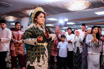 SUNTIK KEJUTAN: Bekas pesilat negara, Cik Nurhanishah Shahrudin, memukau para tetamu apabila beliau membuka langkah silat pengantin ketika majlis perkahwinannya di Changi Civil Service Club, pada 26 September.