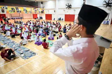 Pelajar Madrasah Wak Tanjong Al-Islamiah, Muhammad Rashdan Mohamed Khairullah, melaungkan azan maghrib di majlis iftar bersama  Sekolah Tinggi Dunman dan Madrasah Wak Tanjong Al-Islamiah pada 28 Mac.