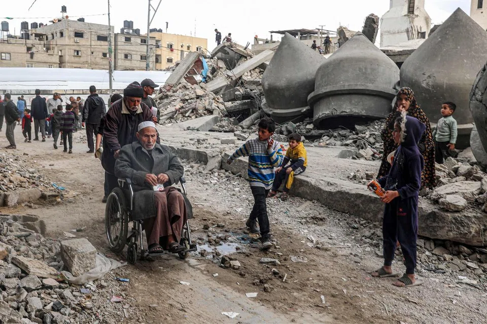 Kanak-kanak bermain di kawasan runtuhan akibat serangan Israel di Rafah pada 17 Mac. Bandar itu, yang hendak diserang Encik Benjamin Netanyahu, menempatkan hampir 1.5 juta penduduk Gaza yang kebanyakannya mencari perlindungan berhampiran sempadan Mesir.
