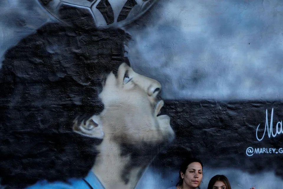 SELAMAT TINGGAL TERAKHIR: Ribuan orang membanjiri jalan raya Buenos Aires yang dilalui kereta jenazah Maradona (atas) ke tanah perkuburan di pinggir ibu kota Argentina itu untuk mengucapkan selamat tinggal terakhir. - Foto EPA-EFE, REUTERS