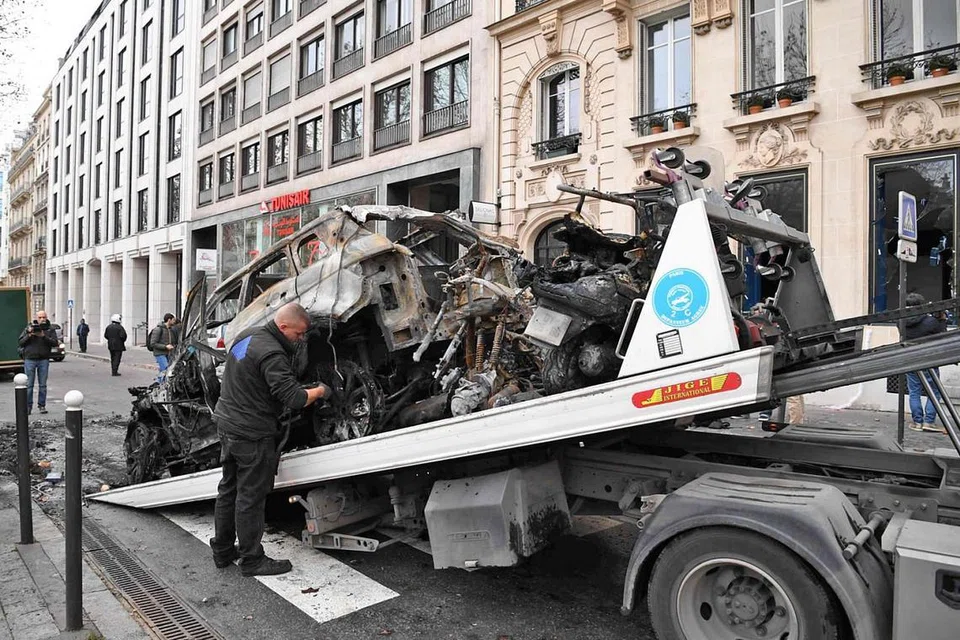 SISA-SISA RUSUHAN: Kereta yang hanya tinggal bangkai setelah dibakar semasa rusuhan penunjuk perasaan 'ves kuning' kelmarin dialihkan ke atas trak tunda semasa operasi pembersihan di Paris kelmarin. Penunjuk perasaan 'ves kuning' itu memprotes kos kehidupan yang kian meningkat di negara itu sambil menuntut peletakan jawatan Presiden Emmanuel Macron. - Foto AFP