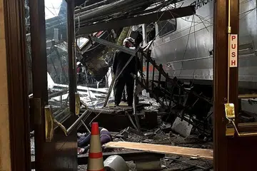 KESAN REMPUHAN: Beginilah kesannya (gambar atas) selepas sebuah kereta api yang sarat dengan penumpang merempuh stesen kereta api di New Jersey. - Foto AFP