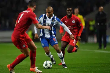 Pemain FC Porto Yacine Brahimi mengawal bola antara pemain pertahanan Luis Hernandez (kiri) dan pemain tengah Ghana Jeff Schlupp Leicester City semasa perlawanan Kumpulan G Liga Juara-Juara di Stadium Dragao di Porto pada 7 Disember 2016 . 