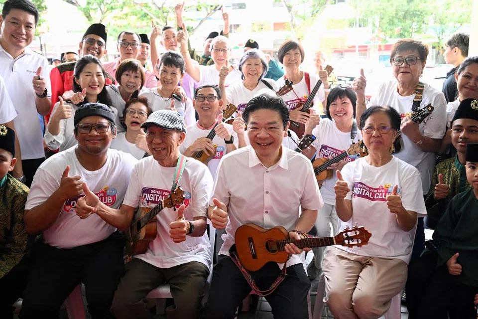 Perdana Menteri Lawrence Wong (depan, tiga dari kanan) bergambar bersama pemain ukulele di acara Seniors’ Connect di Kovan Hub pada 23 Mac.