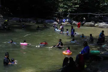 SEJUKKAN BADAN: Orang ramai menyejukkan diri di perairan sungai Kalumpang pada hari panasnya mencecah lebih 33 darjah Celsius, di Tanjung Malim, Perak.