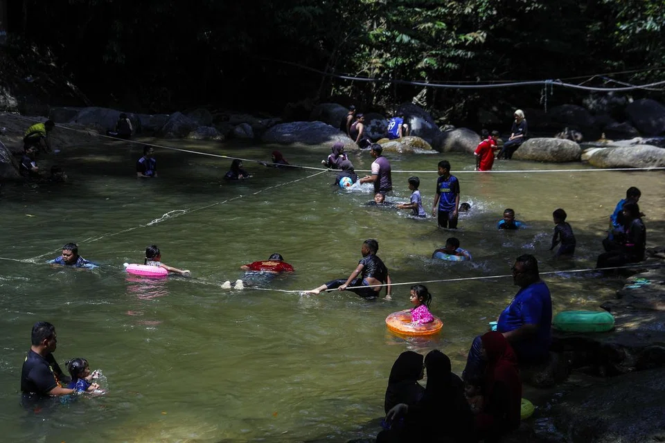 SEJUKKAN BADAN: Orang ramai menyejukkan diri di perairan sungai Kalumpang pada hari panasnya mencecah lebih 33 darjah Celsius, di Tanjung Malim, Perak.
