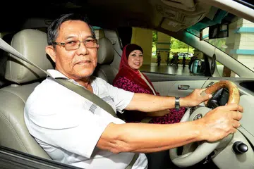 TIADA MASALAH MEMANDU: Encik Rahman memandu semula, termasuk menghantar isterinya, Cik Habsah, ke tempat kerjanya selepas beliau menjalani pembedahan dan terapi selama enam minggu serta ujian memandu yang dikendalikan oleh instruktor memandu, akibat keretakan pada buku lali kanannya. - Foto M.O. SALLEH
