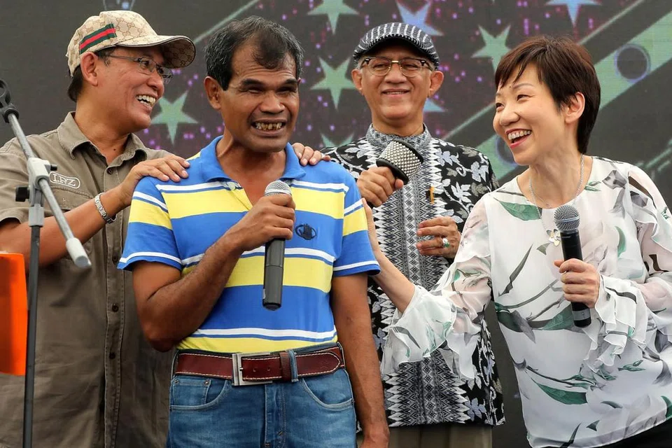 KE ARAH MASYARAKAT LEBIH INKLUSIF: Cik Grace Fu (paling kanan) dan Encik Mohamed Abdullah Alhabshee (dua dari kanan) mendendangkan lagu bersama seorang yang cacat penglihatan semasa acara Rumah Terbuka Cacat Penglihatan Singapura (SAVH) sempena Hari Tongkat Putih Sedunia pada 20 Oktober lalu. - Foto SAVH