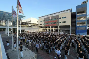 BENDERA SEKOLAH BARU: Para pelajar dan kakitangan Maktab Rendah Tampines Meridian (TMJC) berdiri penuh hormat semasa bendera baru TMJC dikibarkan seiringi bendera kebangsaan semasa perhimpunan pagi di hari pertama sekolah mereka semalam. - Foto BH oleh ALPHONSUS CHERN