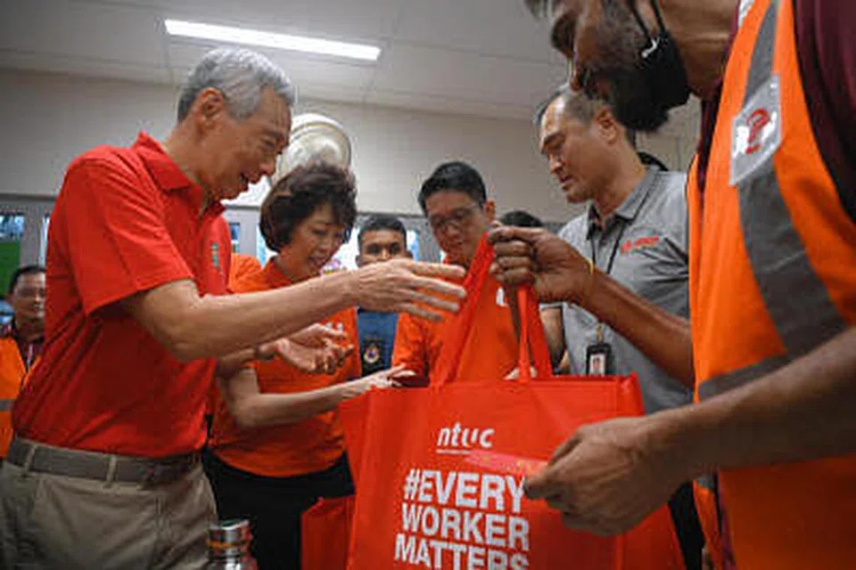 Perdana Menteri Lee Hsien Loong (kiri sekali), bersama Presiden NTUC Mary Liew (dua dari kiri), mengedarkan beg hadiah kepada pekerja pengangkutan awam semasa lawatan ke Hab Pengangkutan Bersepadu Woodlands. - Foto MARK CHEONG