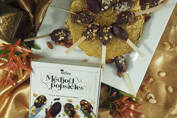 Medjoul Popsicles adalah kurma Medjoul yang dibuang biji dan diisi dengan kacang dan disalut coklat.
