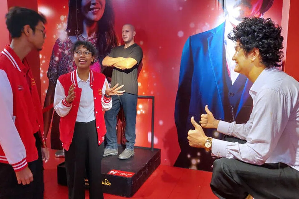 Seorang pelajar yang mengambil bahagian dalam Program Latihan Amali dan Sokongan Kerjaya ITE-SG Enable (SGE) ditemani pelatih kerjayanya yang menerangkan tentang tugas beliau di muzium lilin, Madam Tussauds. 