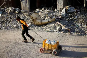 Seorang kanak-kanak Palestin menarik bekas air, di tengah-tengah konflik berterusan antara Israel dan Hamas, di selatan Kota Gaza, di Semenanjung Gaza, 3 Jun 2024.