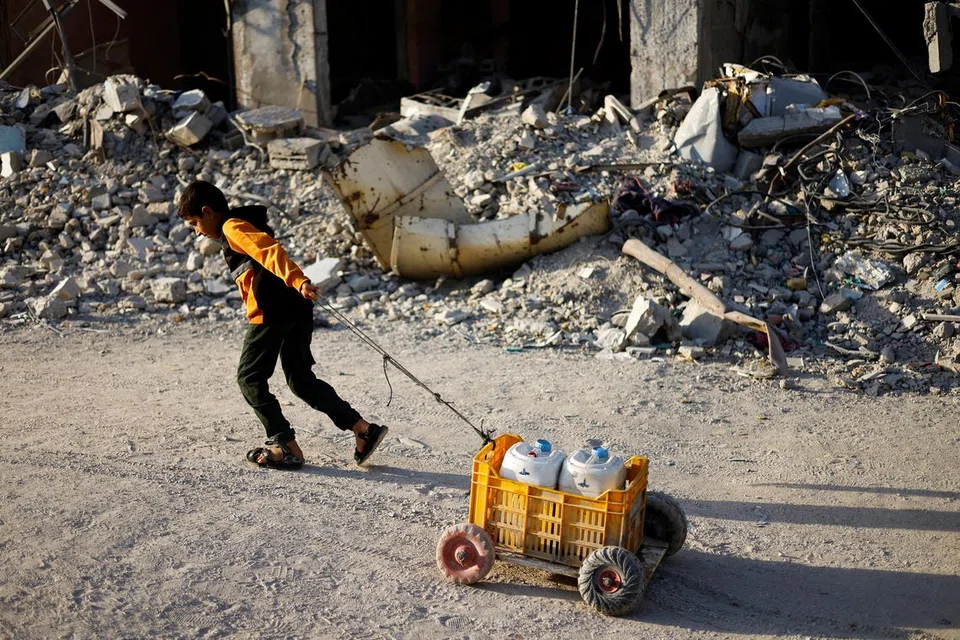 Seorang kanak-kanak Palestin menarik bekas air, di tengah-tengah konflik berterusan antara Israel dan Hamas, di selatan Kota Gaza, di Semenanjung Gaza, 3 Jun 2024.