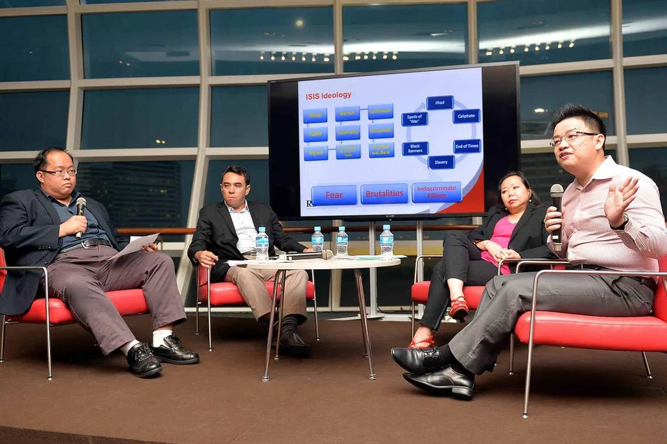 BINCANG ANCAMAN PENGGANAS: Tiga panelis - (dari kanan) Encik Neo Loo Seng, Cik Susan Sim dan Dr Mohamed Ali - membincangkan pelbagai isu dan ancaman pengganasan di Perpustakaan Negara. Sesi itu dipengerusikan Pensyarah Kanan Universiti SIM, Dr Lim Tai Wei (kiri). - Foto M.O. SALLEH