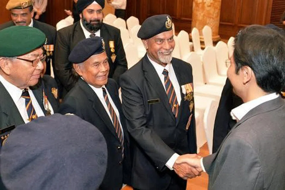 PERINGATI JASA PERINTIS: Encik Lawrence Wong (kanan) berjabat tangan dengan Encik Mohd Saleh, salah seorang perajurit perang semasa pendudukan tentera Jepun di Singapura. - Foto KHALID BABA