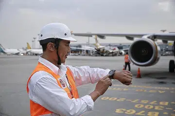JAM CANGGIH: Seorang pengurus tanjakan teknikal menggunakan jam bijaknya serta fon kepala yang membolehkannya membuat panggilan telefon dengan mudah dan selamat. - Foto THE STRAITS TIMES