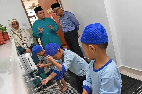 DIDIK SEJAK KECIL: Encik Masgos diberi taklimat oleh Pengerusi Eksekutif Masjid Mujahidin, Encik Muhammad Khairul Jameel Yahya, mengenai kanak-kanak di tadika Masjid Mujahidin yang diajar cara mengambil wuduk dengan melakukannya secara menjimatkan air. - Foto BH oleh DESMOND FOO