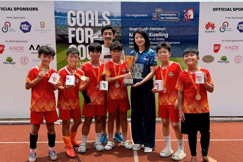 Menteri Negara Kanan (Pengangkutan merangkap Pembangunan Negara), Cik Sun Xueling, bergambar bersama kanak-kanak yang memenangi perlawanan di kejohanan bola sepak amal Goals For Good 2026 anjuran CHIJ Sanctuary for Children (CHIJSC).