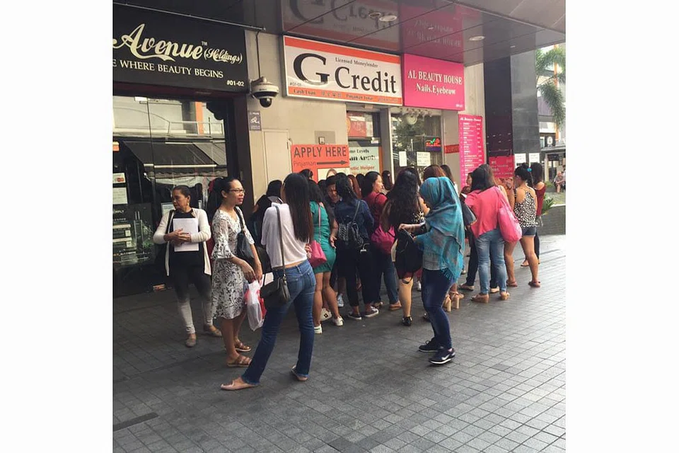 SUDAH MULA BERATUR: Gambar yang dipetik dari Facebook ini menunjukkan sekumpulan pembantu rumah dari pelbagai negara beratur di luar sebuah kedai pemiutang berlesen. - Foto FACEBOOK FDW EMPLOYERS @ SINGAPORE