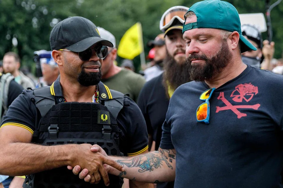DIDAPATI BERSALAH: Joseph Biggs (kanan) yang bersalaman dengan Enrique Tarrio (kiri), pengerusi kumpulan Proud Boys, dijatuhi hukuman penjara 17 tahun kerana konspirasi menghasut serangan ke atas bangunan Capitol di Amerika Syarikat pada 2021.