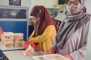 JUALAN AMAL: Kaum Muslimah di Masjid Hasanah turut bantu menjual nasi beriani amal pada 16 Jun sebagai sebahagian daripada usaha mengumpul dana untuk projek peningkatan masjid. 