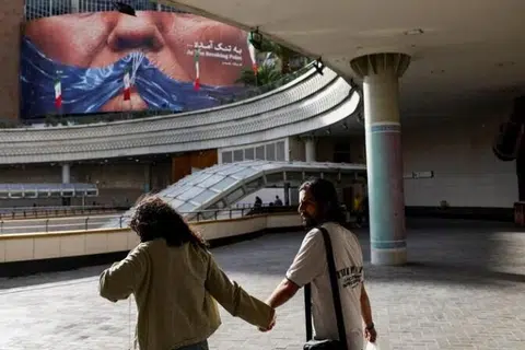 Orang ramai berjalan melintasi papan iklan anti-Amerika Syarikat yang memaparkan Presiden Amerika Syarikat, Encik Donald Trump, dan Selat Hormuz di Teheran, Iran, pada 17 Mei 2026.
