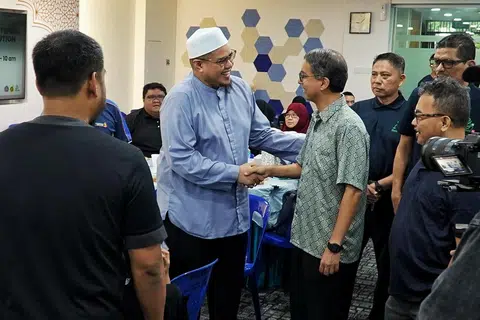 Ustaz Zulhilmi Mohamed, Pengarah Eksekutif Perdaus (bersongkok) bersalaman dengan Profesor Madya Dr Muhammad Faishal Ibrahim semasa acara Pengagihan Daging Korban Rangkaian Pemulihan Badan Melayu/Islam di Masjid An-Nur pada 29 Jun.